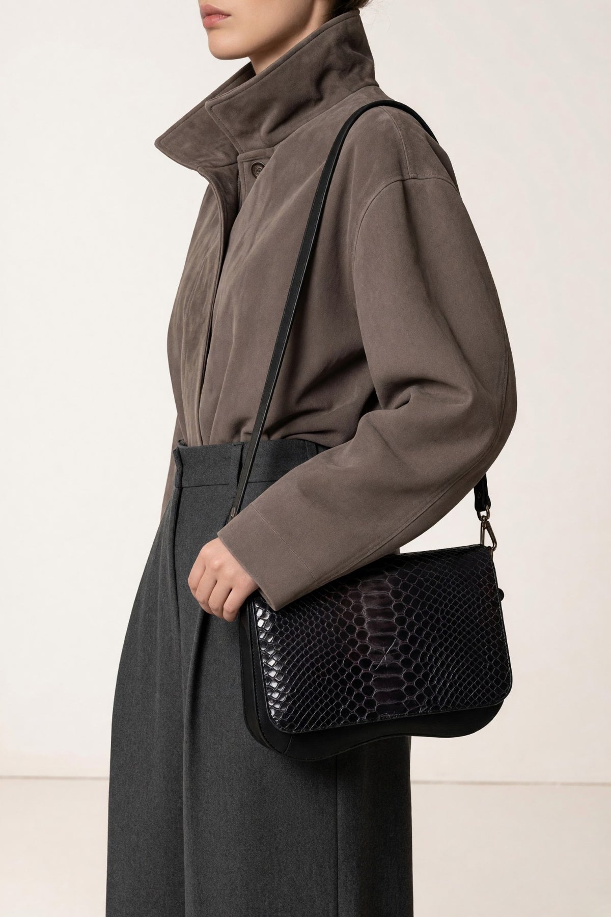 Sac Baby Double avec le rabat Pyth noir et ambré, porté à l'épaule