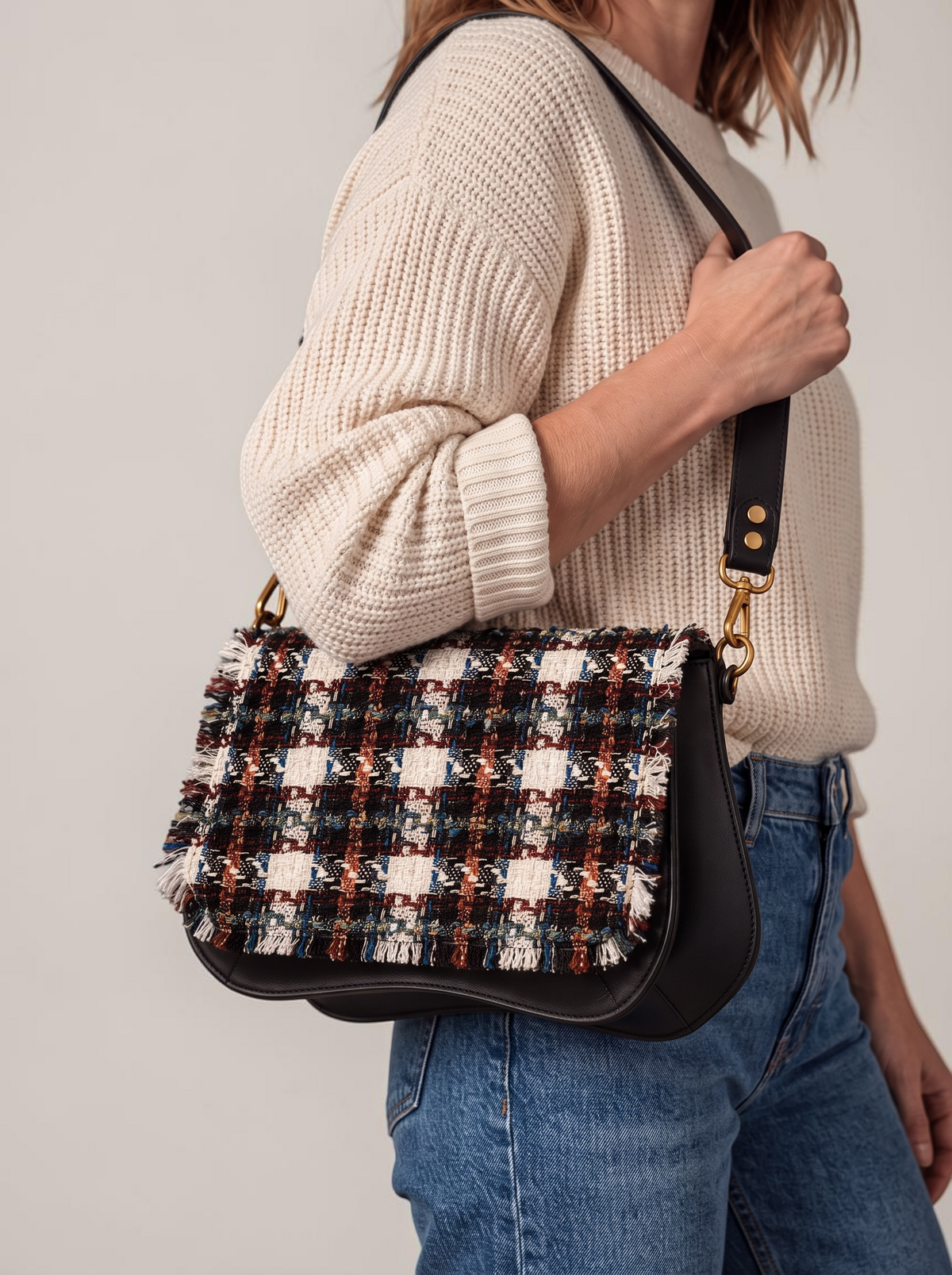 Sac Baby Double avec rabat Caro en tweed porte a l epaule, bandouliere cuir noir, sur un jean et un pull ecru