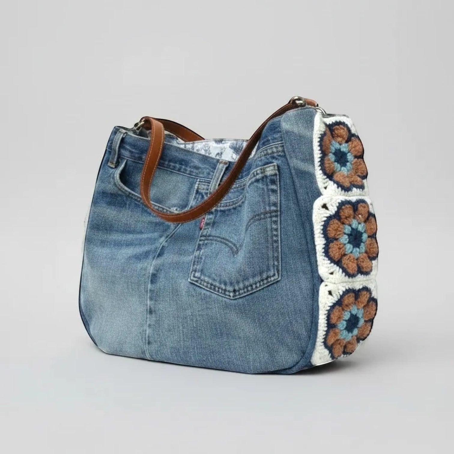 La Stella cabas en jean upcyclé bleu avec granny squares au crochet caramel, bleu et écru, anses en cuir.